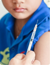 Close-up of a child receiving a vaccination in their arm from a healthcare provider with a syringe.