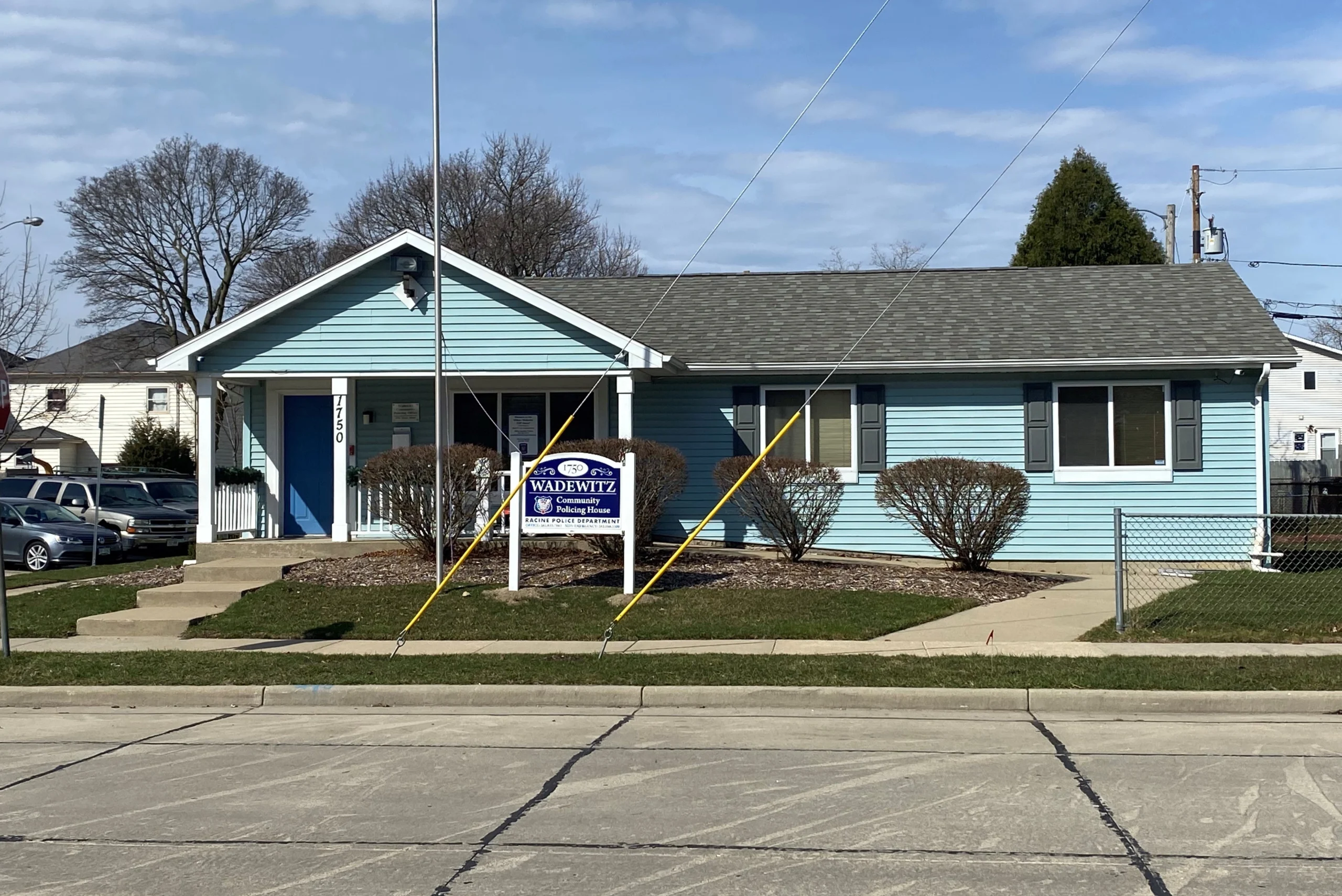 Exterior view of the Waterford Town Hall, a light blue building with a gray roof and a sign in front.