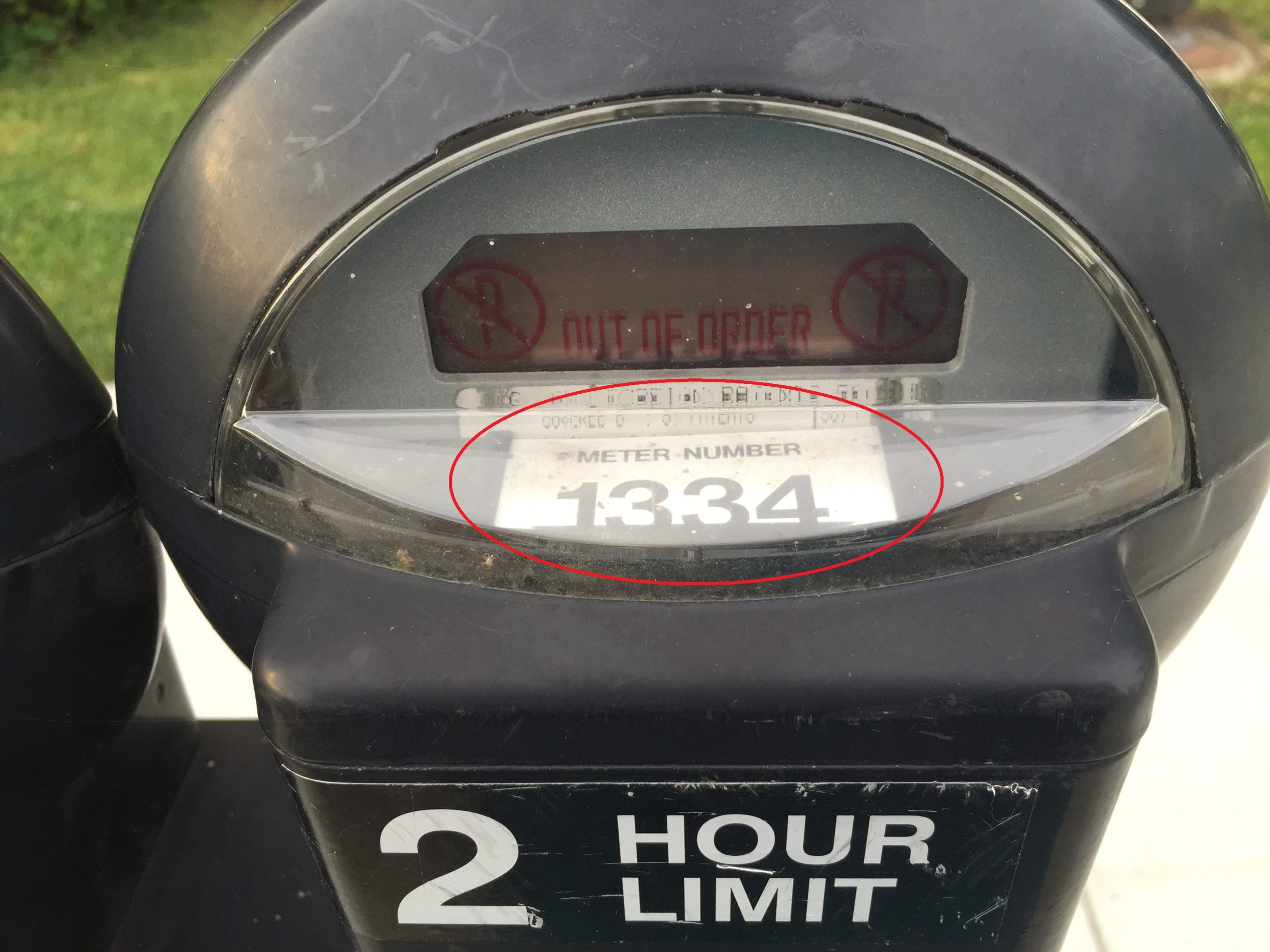 Close-up of a broken parking meter displaying 'OUT OF ORDER' and meter number 1334, circled in red.