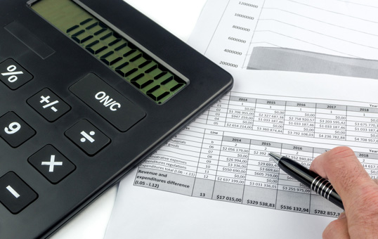 Calculator displaying '1000000' with financial reports and a pen, suggesting financial analysis or accounting.