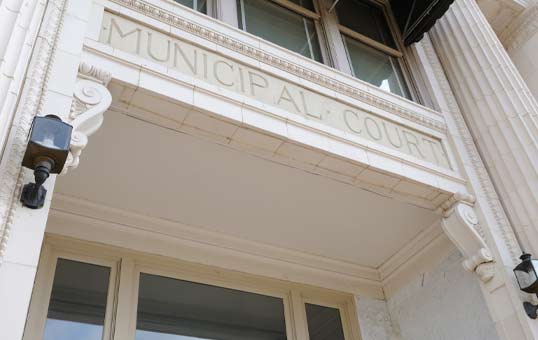 Entrance to a Municipal Court building with the words 'Municipal Court' carved above the doorway.