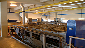 Industrial water filtration system with metal grates and pipes in a large, brightly lit room.