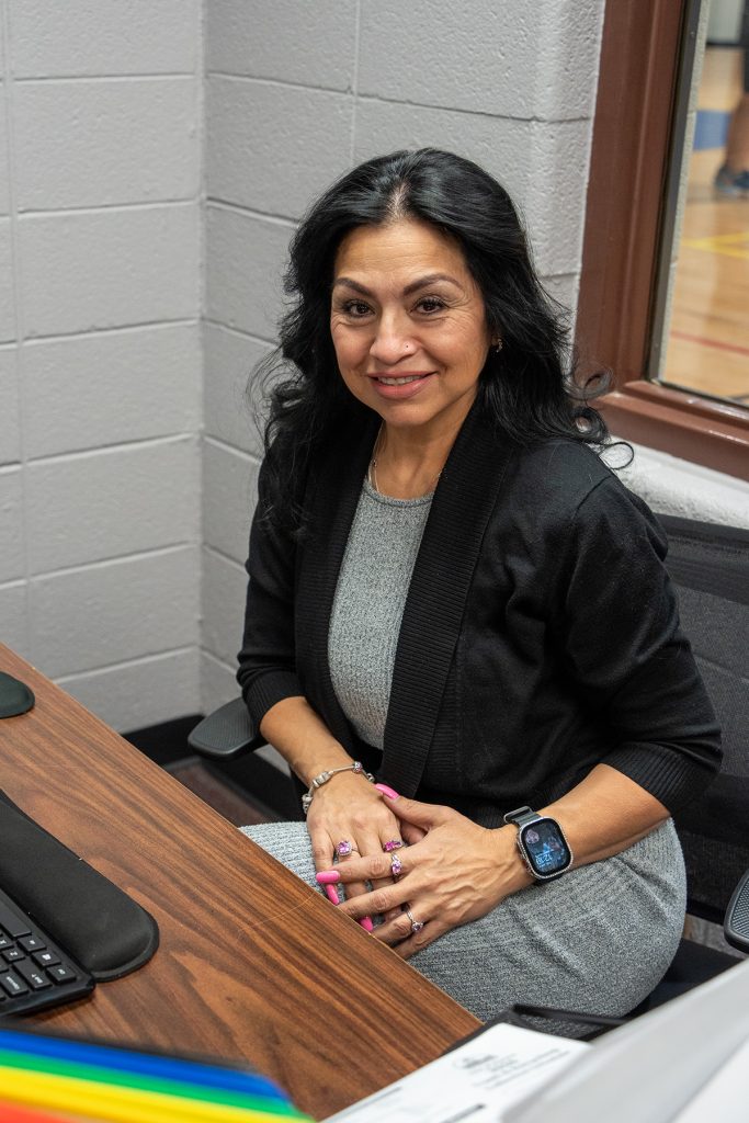 photo of a dark-haired woman sitting at a desk in an office